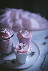tasty glasses of strawberry mousse on a table with flowers