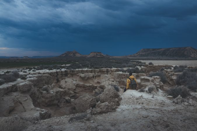 Man standing on stone in desert hills