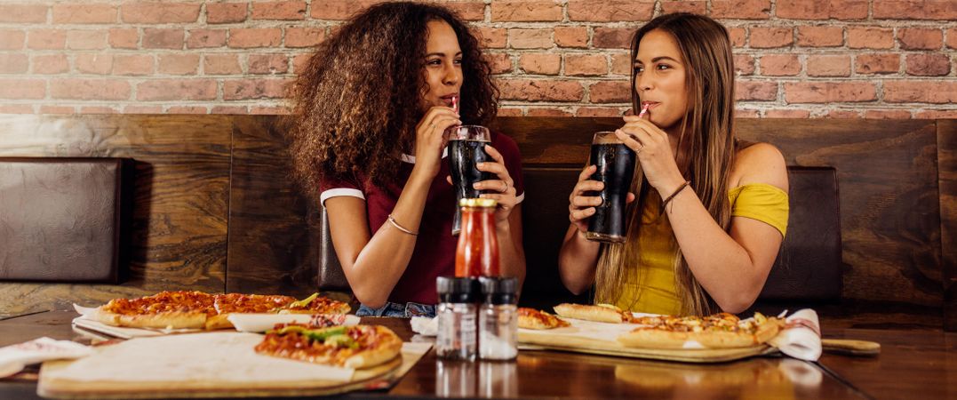 Multi-ethnic female friends sitting at restaurant having lunch together