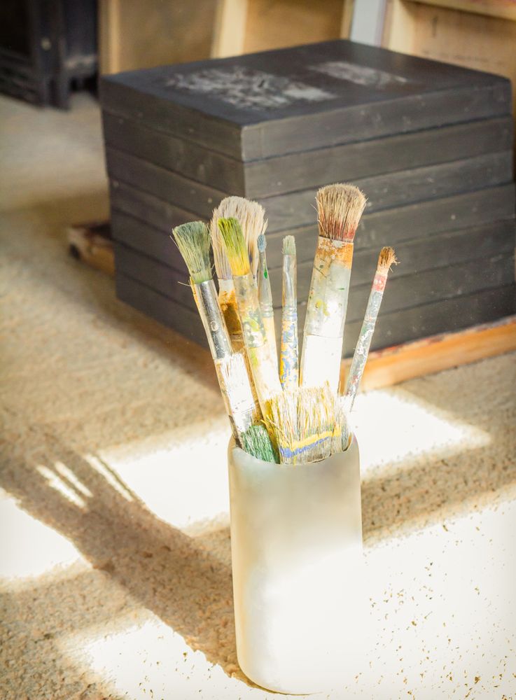 Paint brushes set in front of canvas