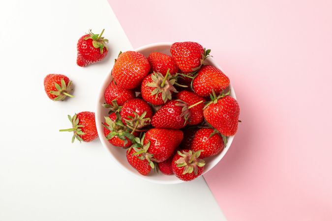 Bowl with tasty strawberry on two tone background. Summer berry