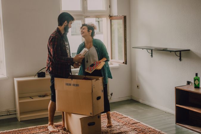 Casual couple unpacking boxes in apartment