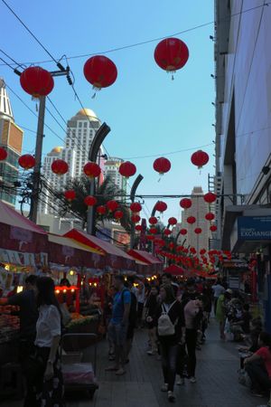 People walking in street market decorated with Chinese New Year red Lantern