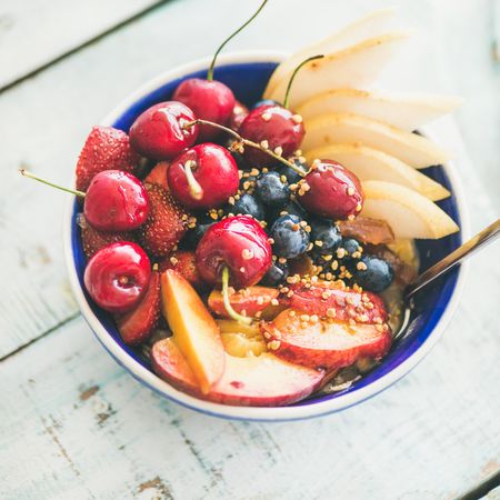 Bowl of fresh fruit with cherries, peaches, blueberry, strawberries, square crop