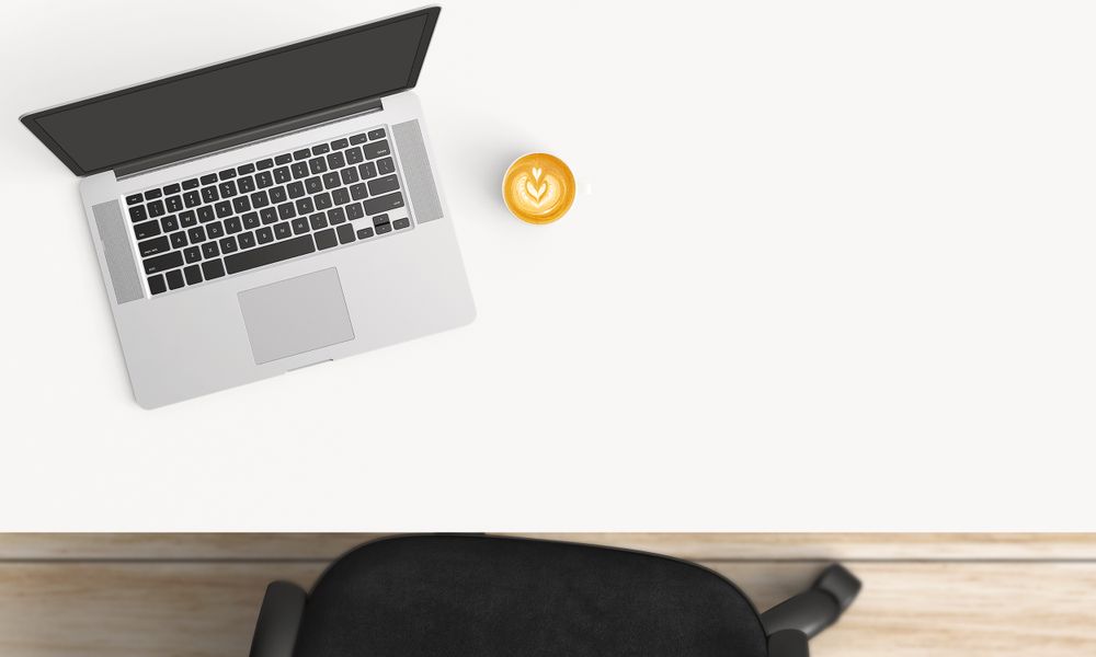Modern workplace with laptop, coffee cup and notebook copy space on table background. Top view. Flat lay style.