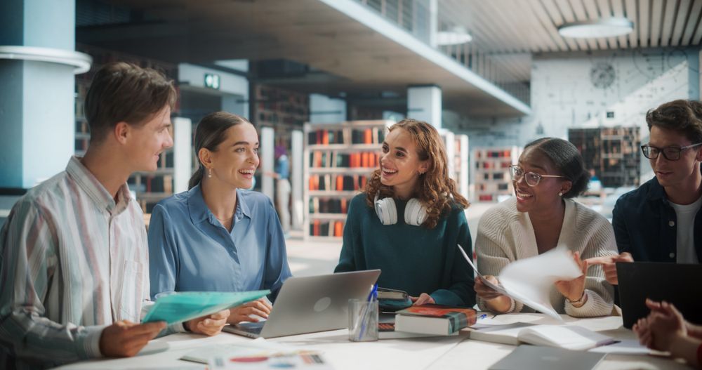 Diverse Group of Students Collaborating on a Project in a Modern Library.