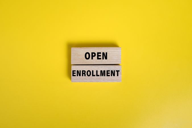 open enrollment words on wooden blocks isolated on yellow background