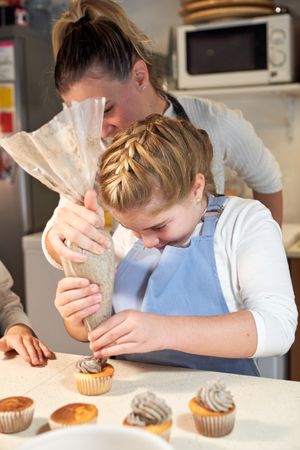 Mother and daughter preparing cookies in kitchen