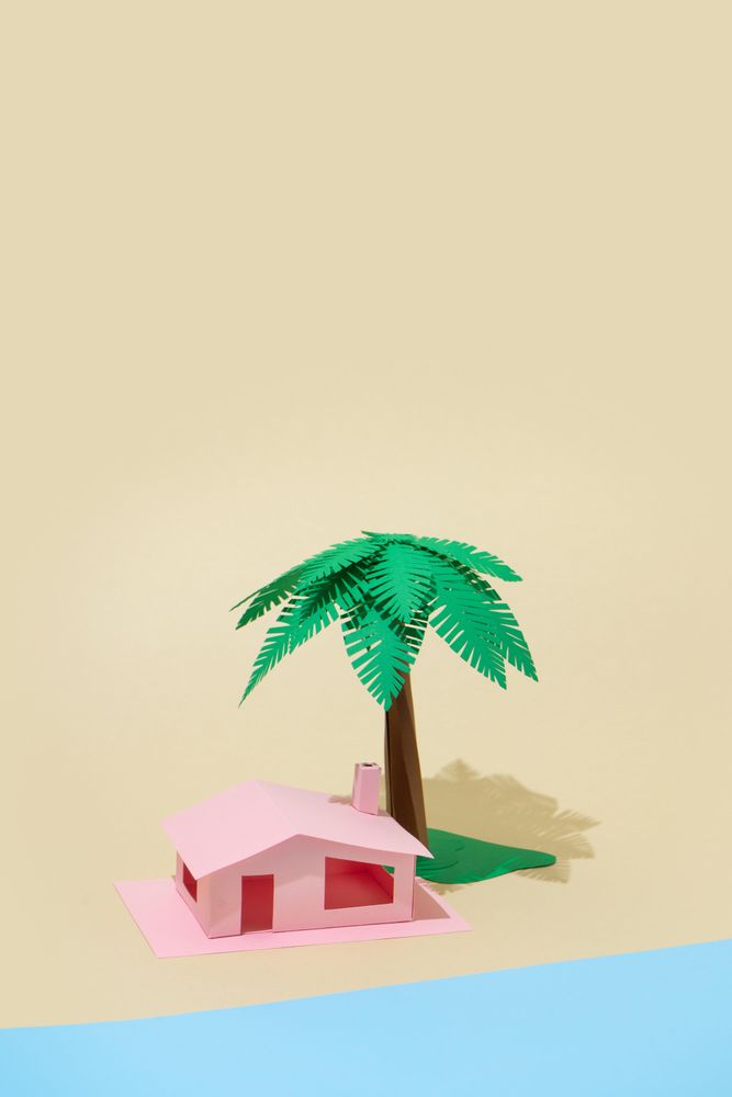 Palm tree and pink house made of paper on beige background