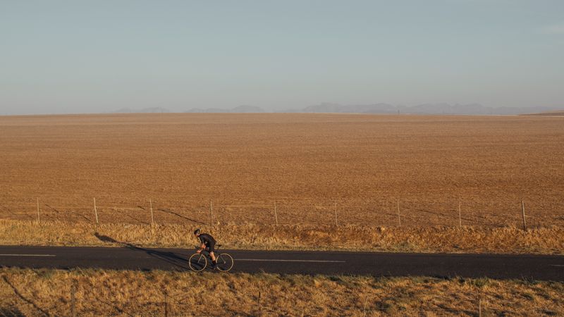 Cyclist riding a bike on asphalt road in countryside