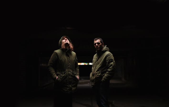 Partners standing alongside each other  under the dramatic light.