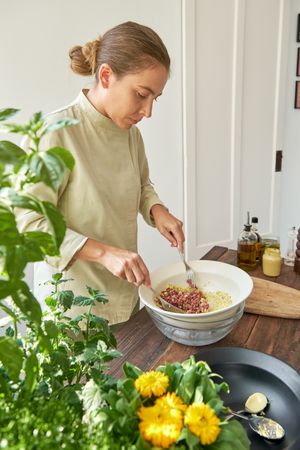 Woman mixing ingredients for steak tartare preparation