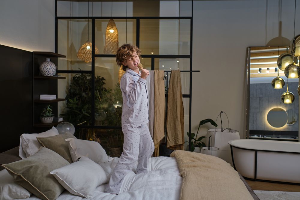 Boy singing on bed in bedroom