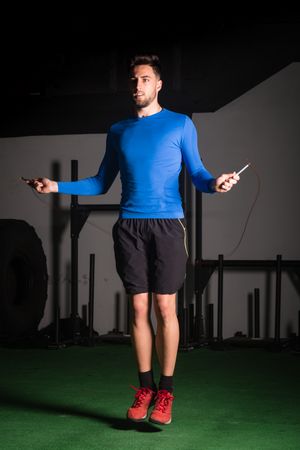 Man exercising with jump rope in gym