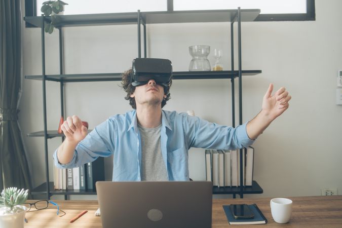 Creative designer excitedly watching something on VR glasses in office