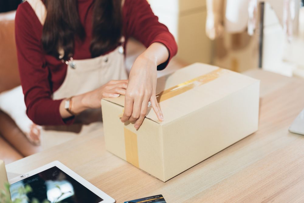 Female sealing a package or orders at home