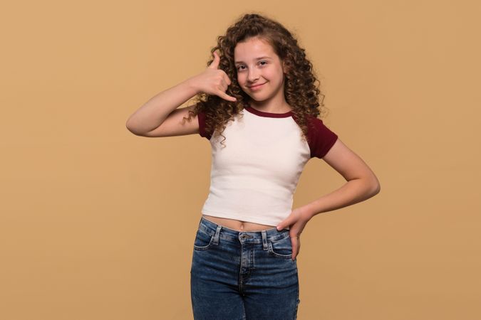 Young girl gesturing call me sign