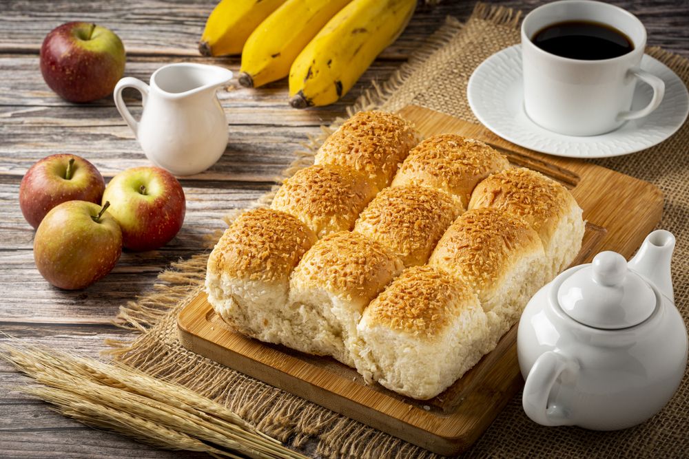 Breakfast table with coconut bread and fruits.