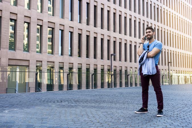 Man in casual dress talking on his phone outdoors