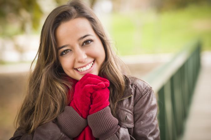 Portrait of Smiling Woman Wearing Red Scarf and Mittens Outside