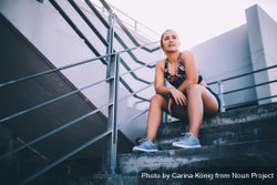 Young woman sitting on stadium stairs looking in the distance x42Lq0