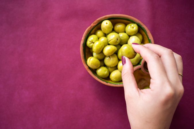 Asian woman eating olives in restaurant