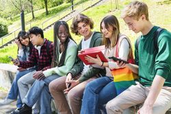 Multi-ethnic group of students sitting outside on campus