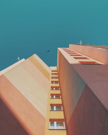 Low-angle photography of brutalist colorful architecture under blue sky