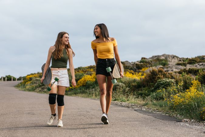 Cheerful diverse women walking on the road