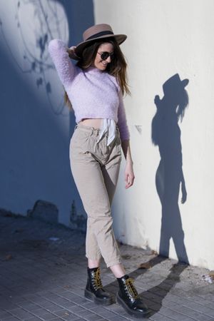 Young woman wearing sunglasses and hat outside with shadow