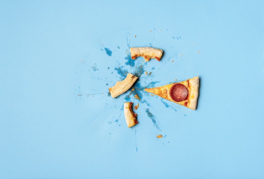 Single pizza slice and messy leftovers