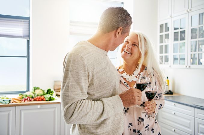 Mature couple looking into each others eyes in bright kitchen