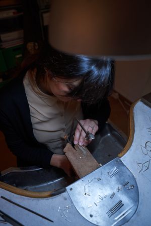 Focused female artisan working with job saw on finagel