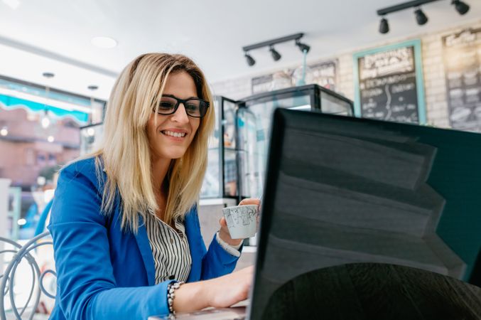 Woman drinking coffee and chatting with the laptop