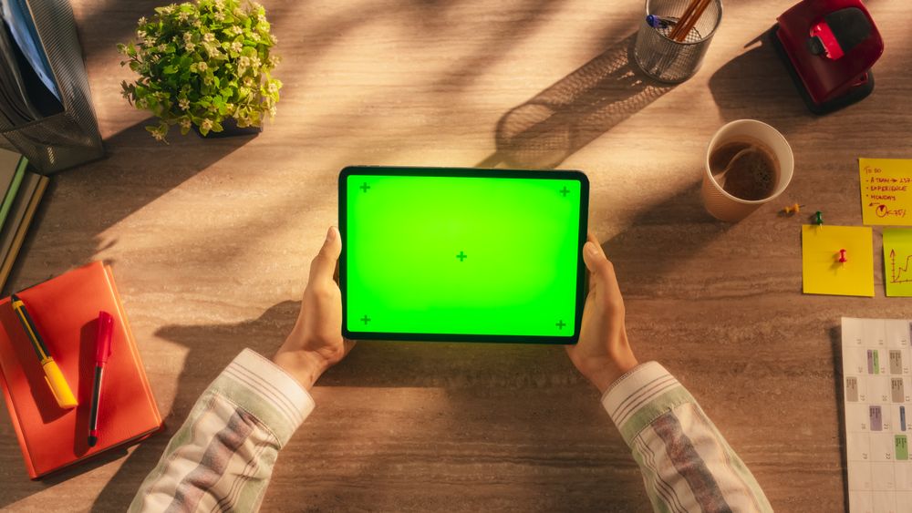 Anonymous Office Manager Holding Tablet Computer with Green Screen Mock Up Display, Sitting Behind a Wooden Desk in a Creative Agency. Photo Template for Digital Presentations, Communication Materials