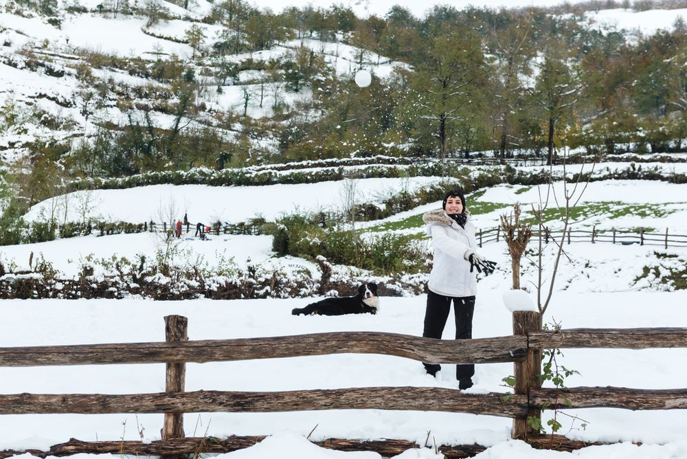 Happy woman play snowballs in countryside