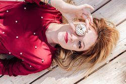 Woman looking through donuts hole on picnic