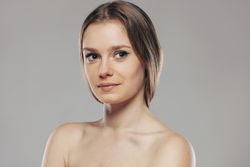 Blond woman without shirt posing in studio