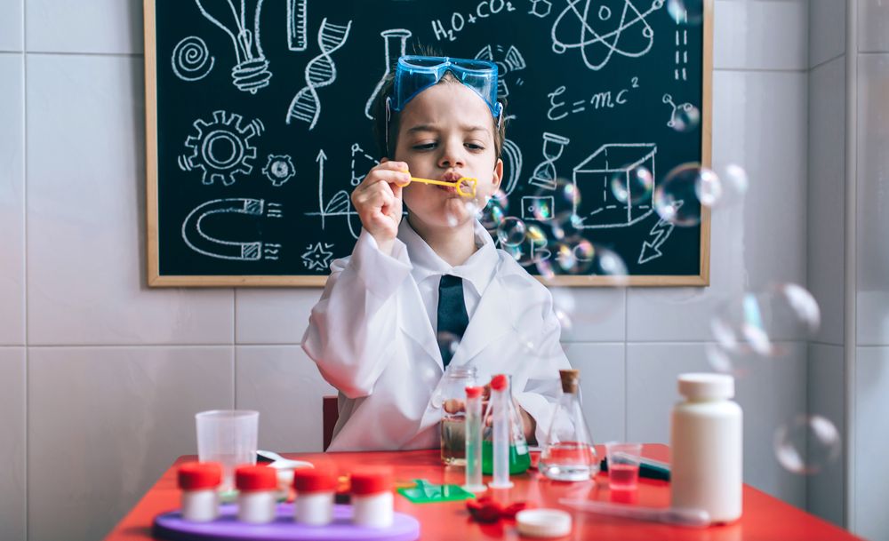 Kid doing soap bubbles in toy laboratory