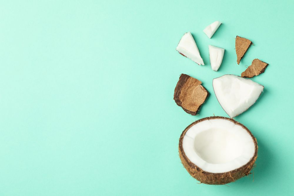 Flat lay with coconut on mint background, top view