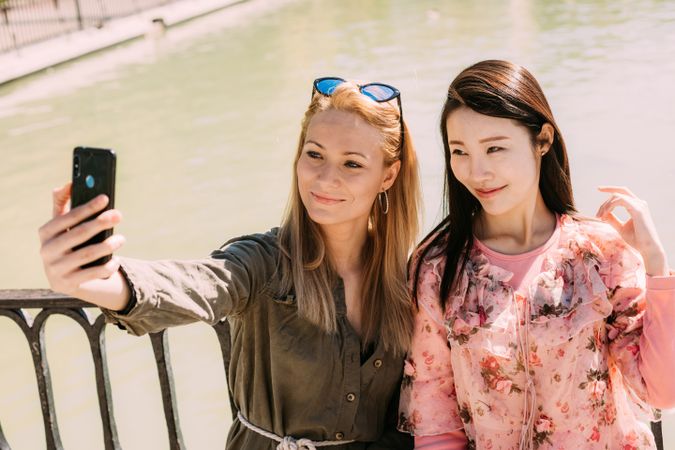 Multiethnic friends taking a selfie photo on embankment