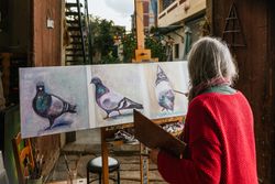 Anonymous mature woman painting on canvas in garden