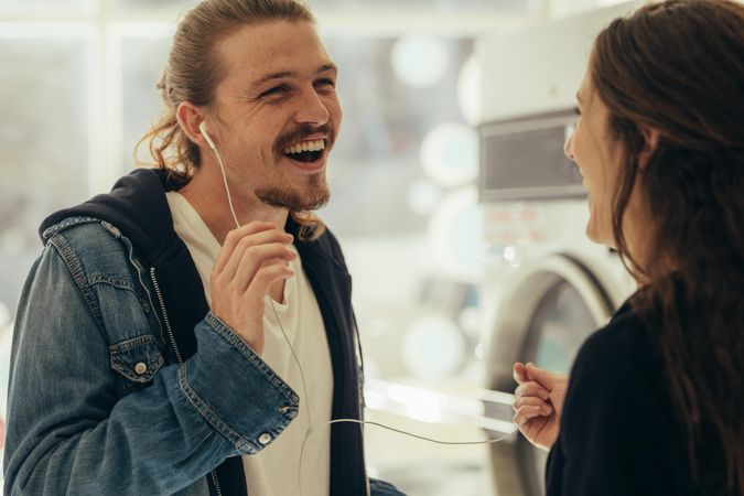Happy man talking to a woman while listening to music