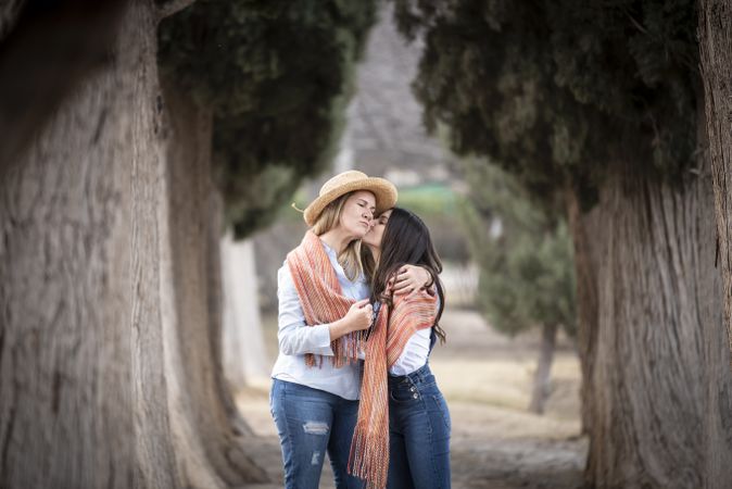 Mother and daughter hugging nears trees