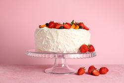 Berry cream cake on pink background. Delicious dessert