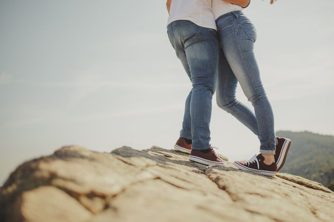 Loving couple embracing while standing at mountain cliff