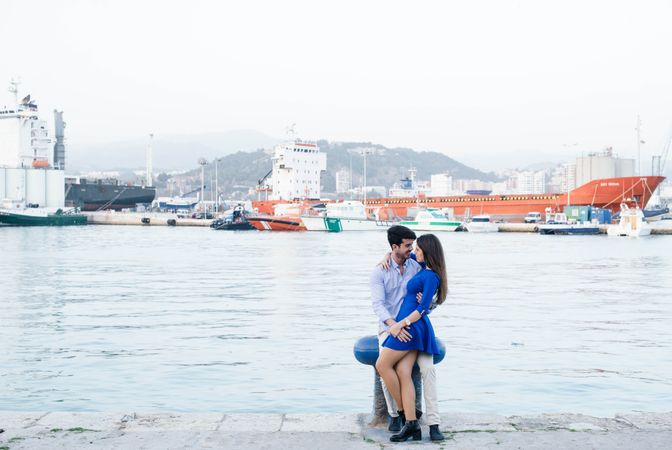 Loving couple embracing on urban pier with dock