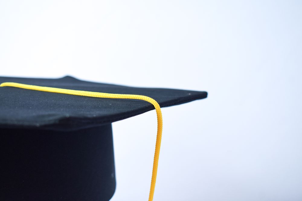 Graduation cap in plain studio with copy space