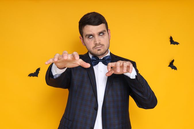 A man in a zombie costume on a yellow background