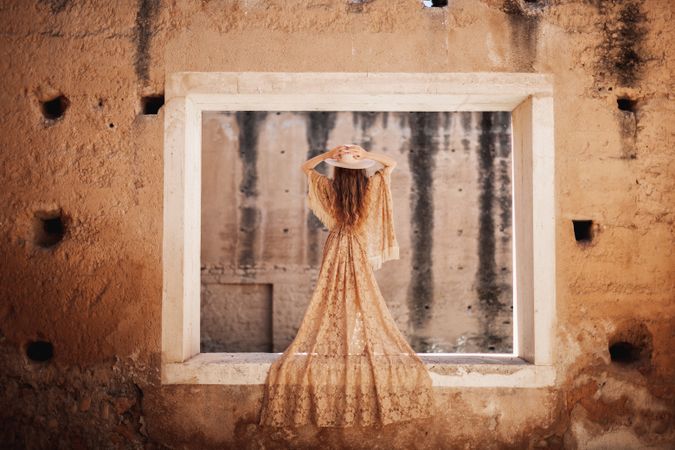 Elegant female in long dress on window